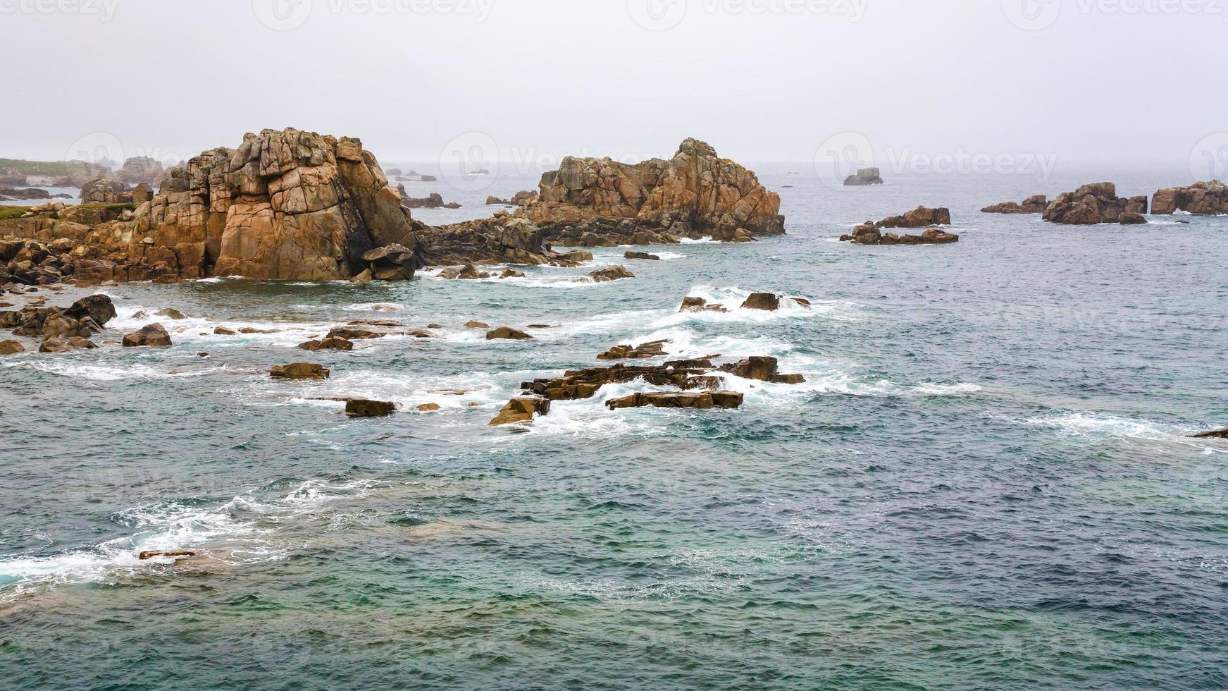 view of rocky coastline in Brittany in rainy day photo