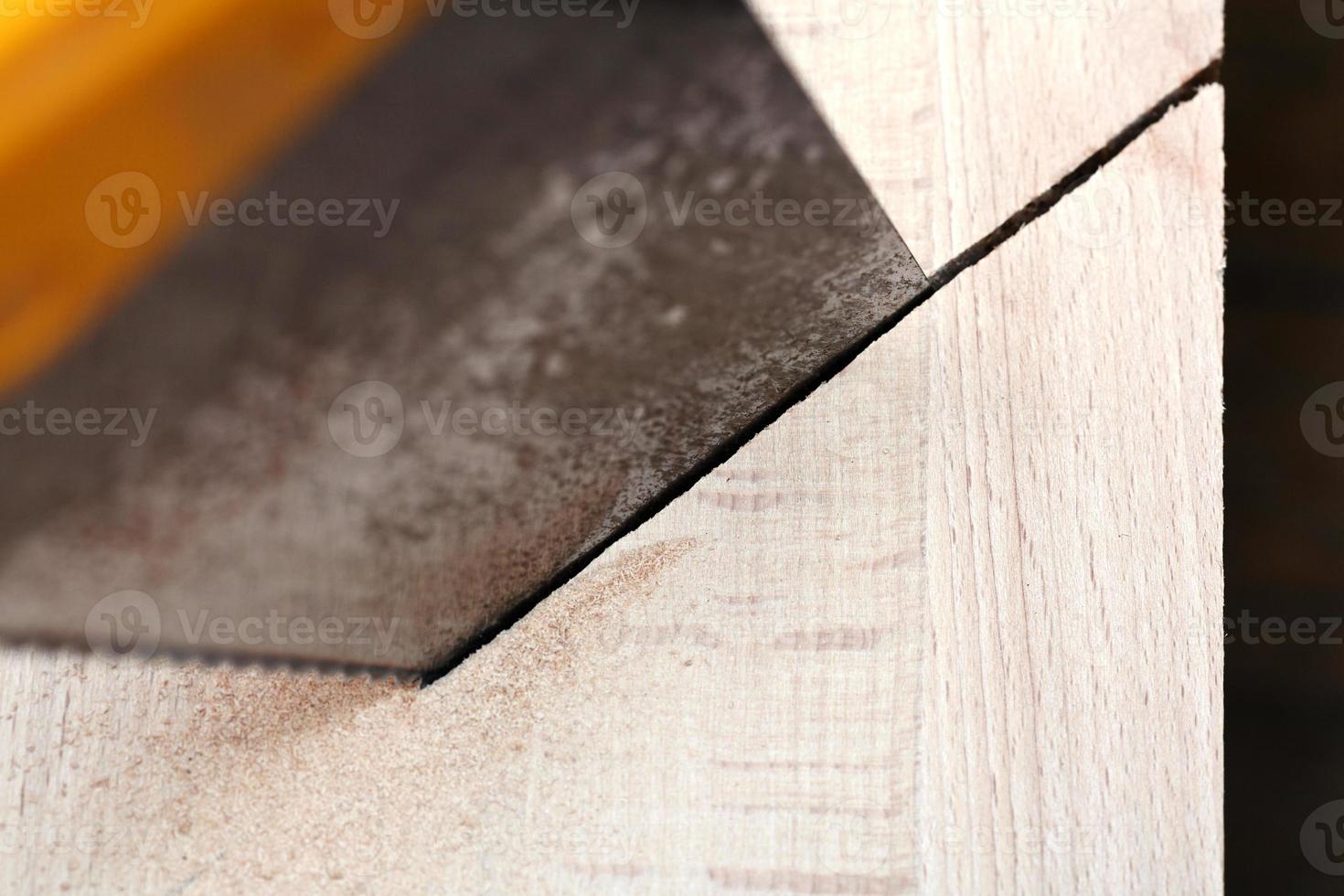 wooden board is cut with hacksaw photo