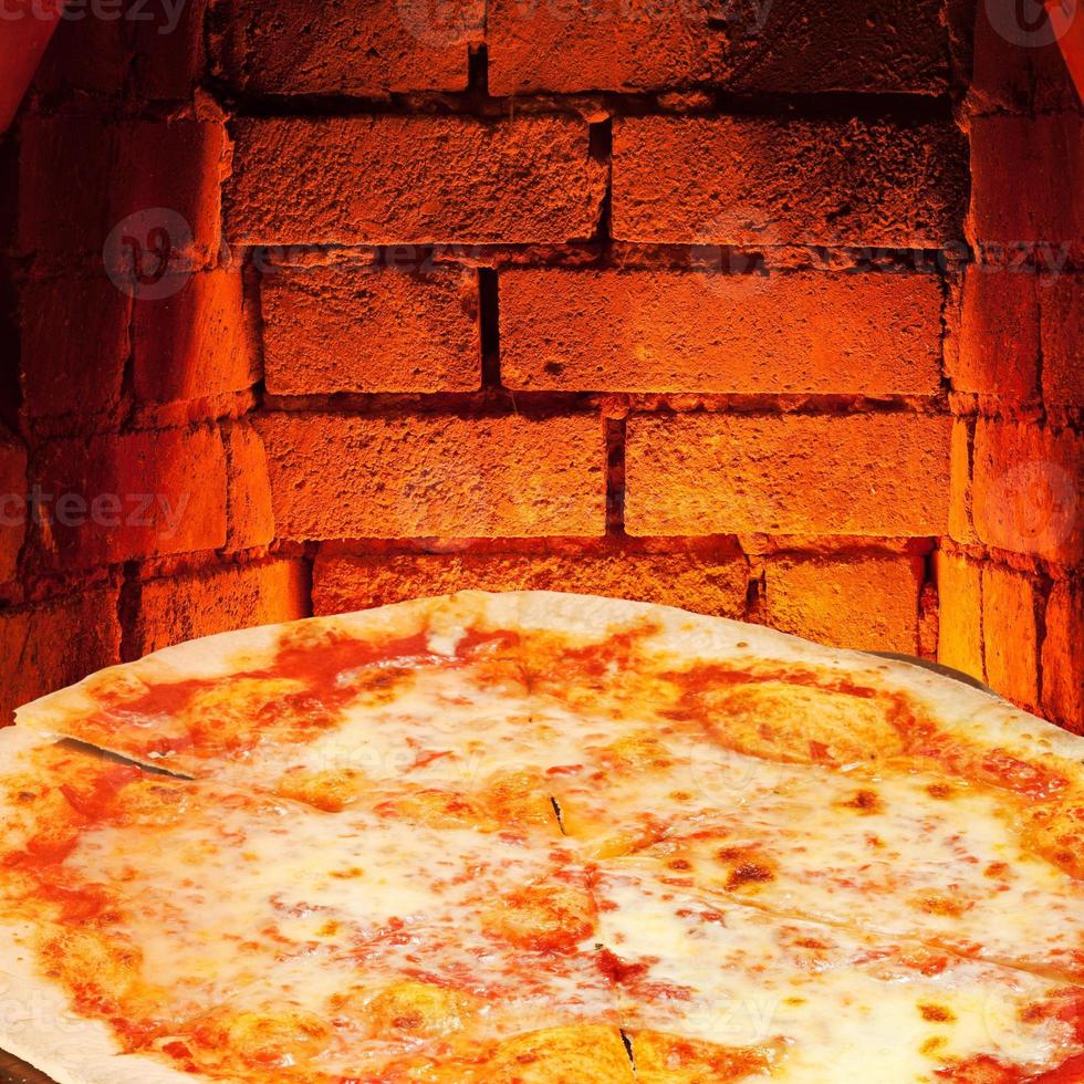 pizza margherita and hot brick wall of oven photo