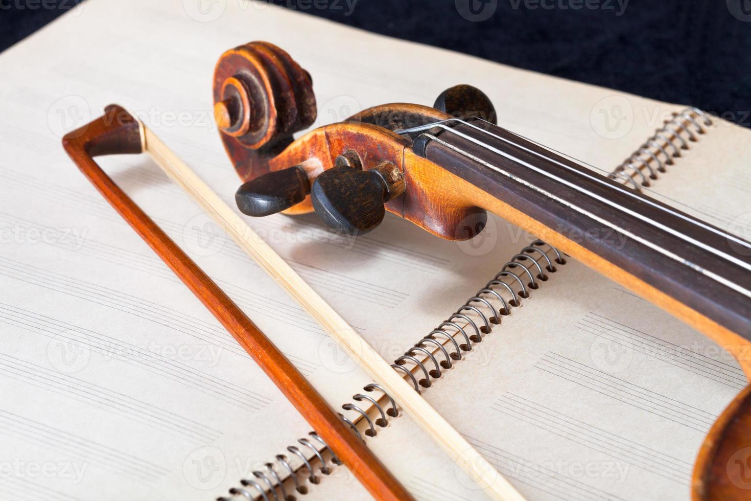 violin bow and scroll on music book photo