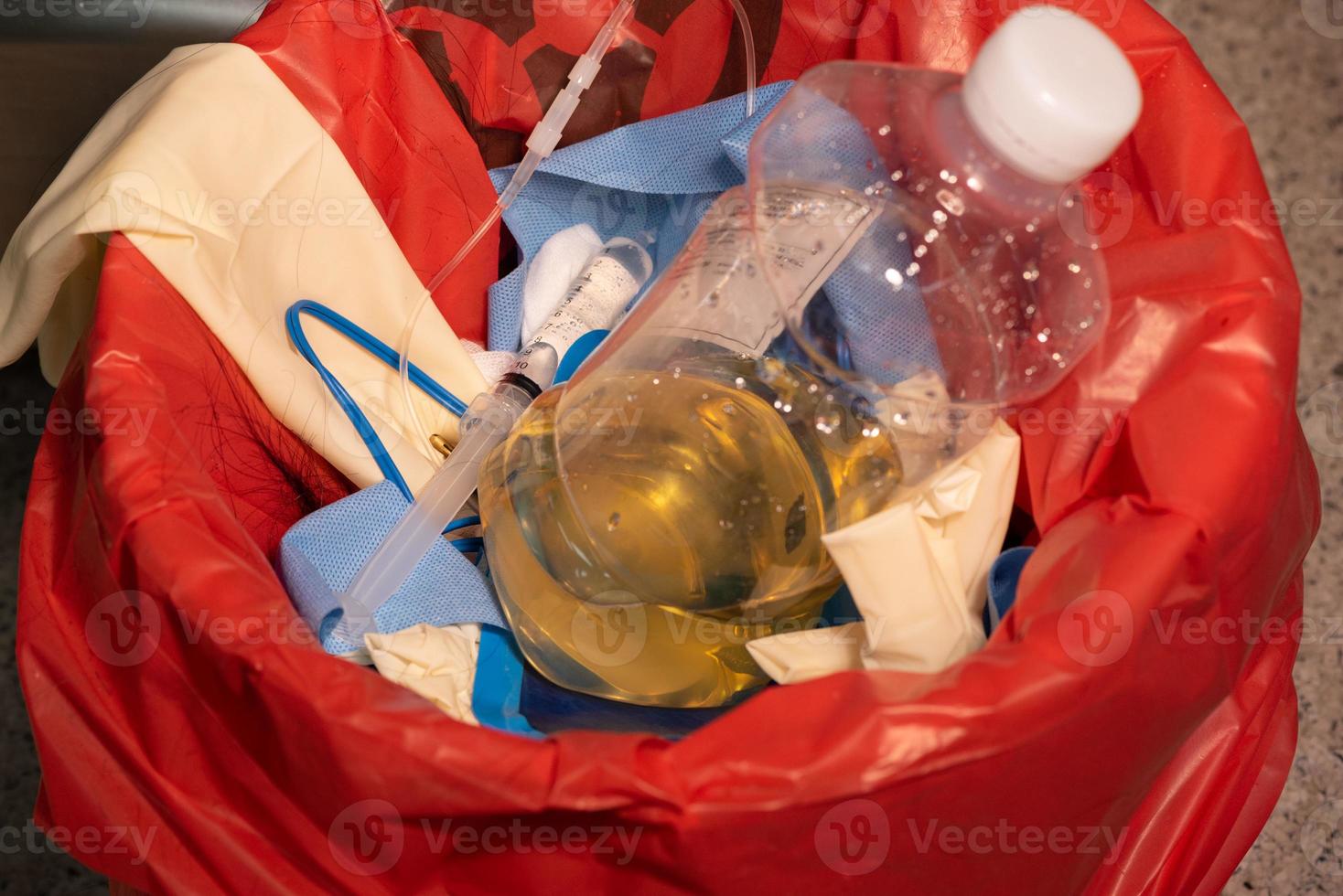 Urine bottle in red garbage photo