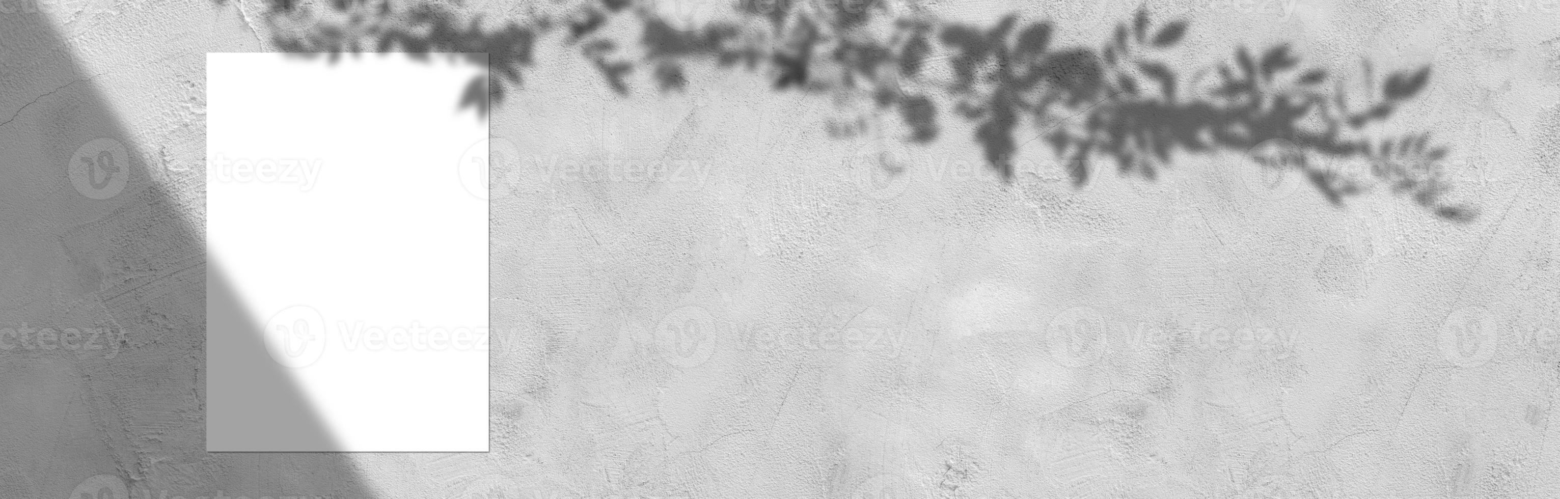 Empty white horizontal rectangular poster mockup with light shadow on gray concrete wall background. photo