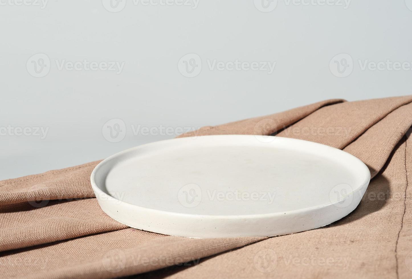 empty stand plate on a canvas beige napkin. mock up for food, template for menu. ready for food presentation. front view photo