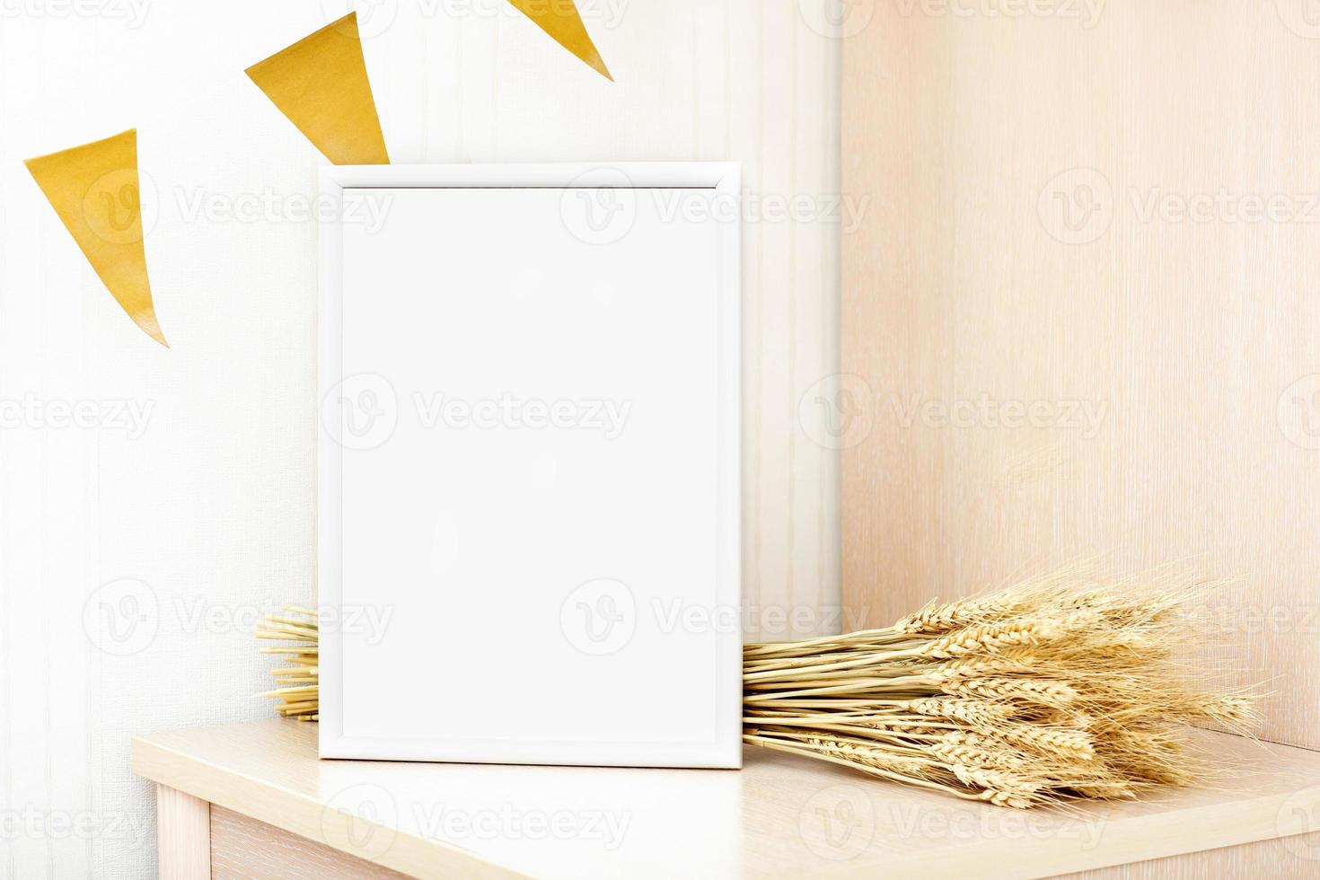 white frame with copy space and barley spiklets on a table. autumn sale or inspirational text mockup. seasonal party, celebration of harvesting, country minimal style. photo