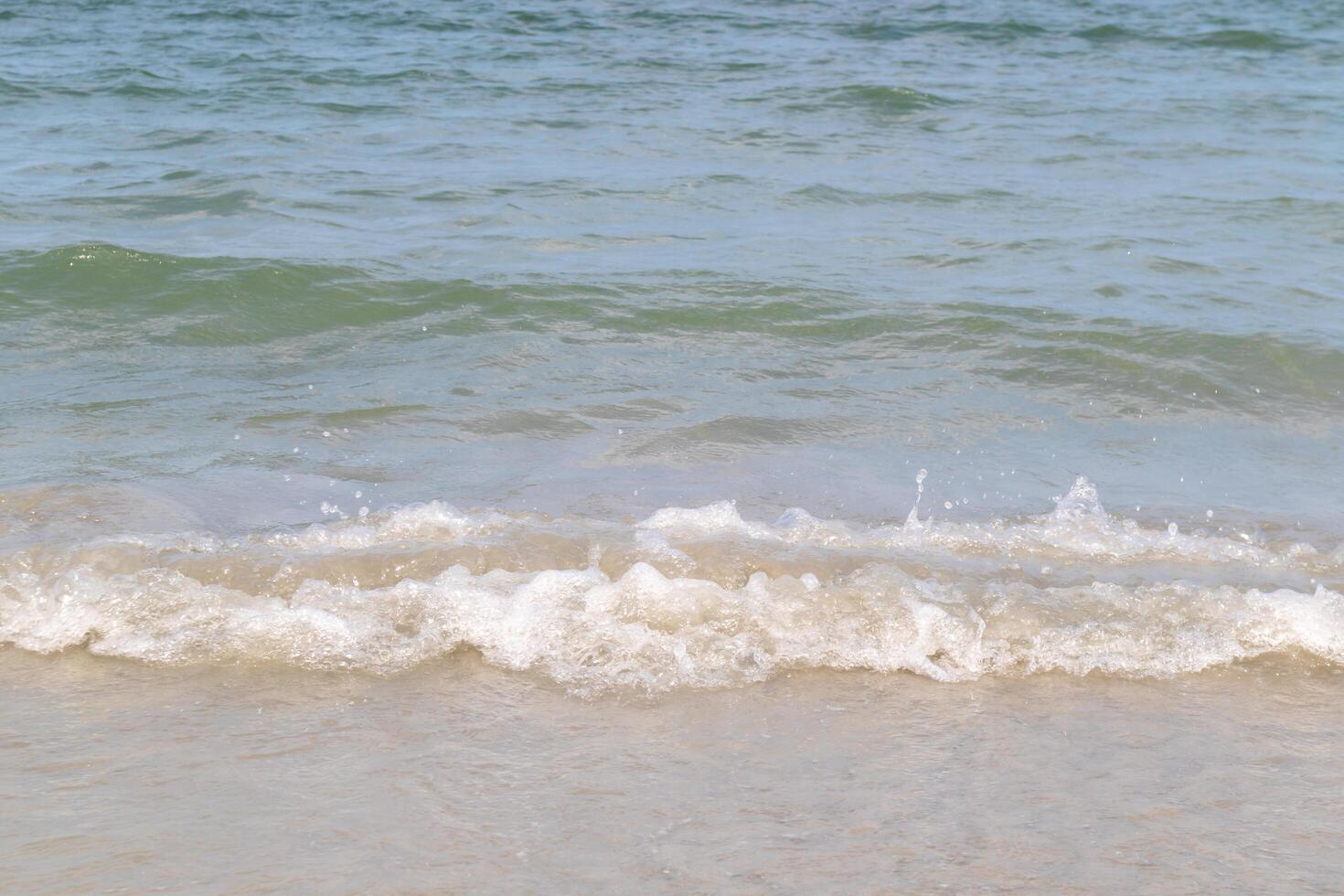 The ocean waves that blow into the beach at the time of clear sky photo