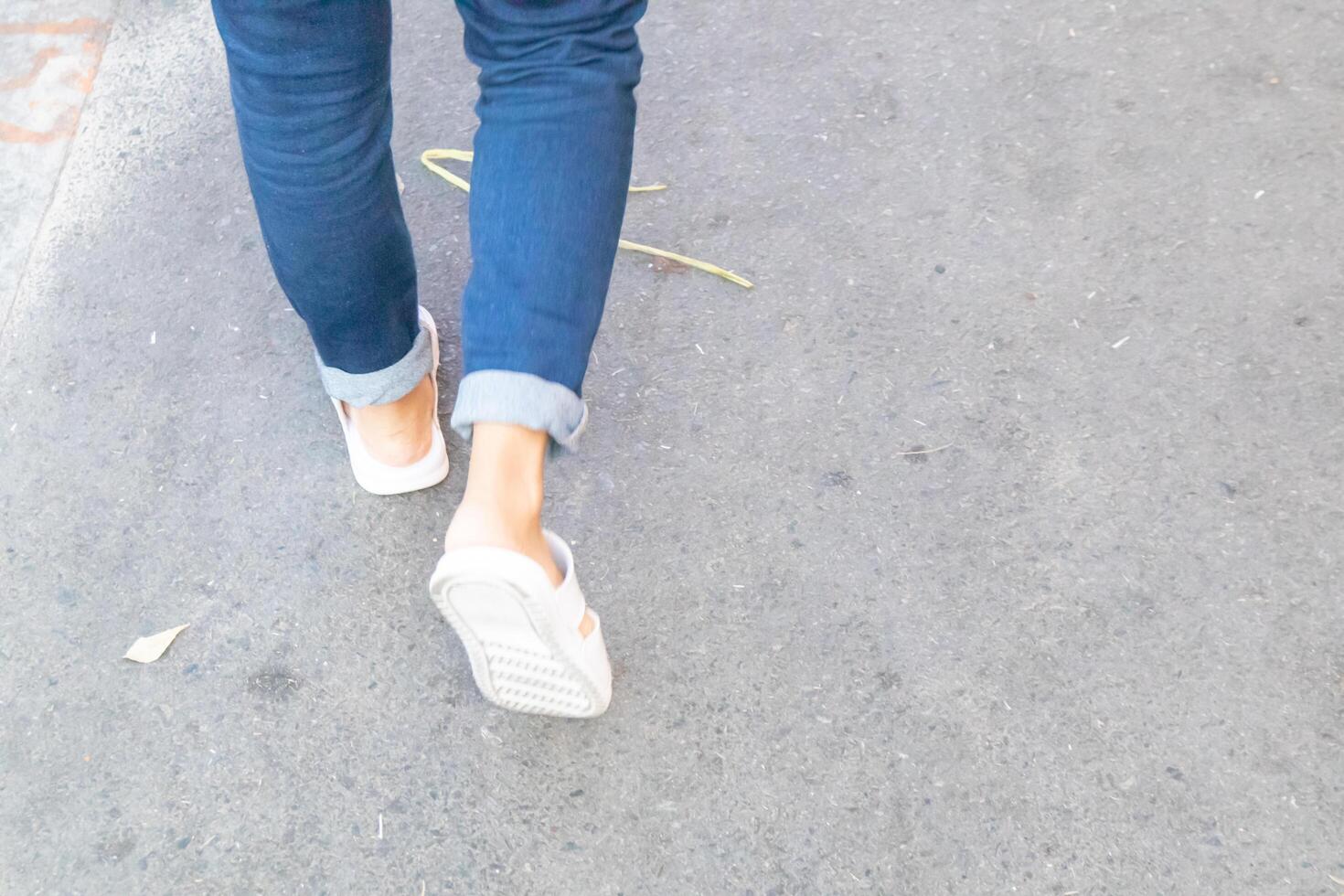 Backside view of person which walk on the concrete road. photo