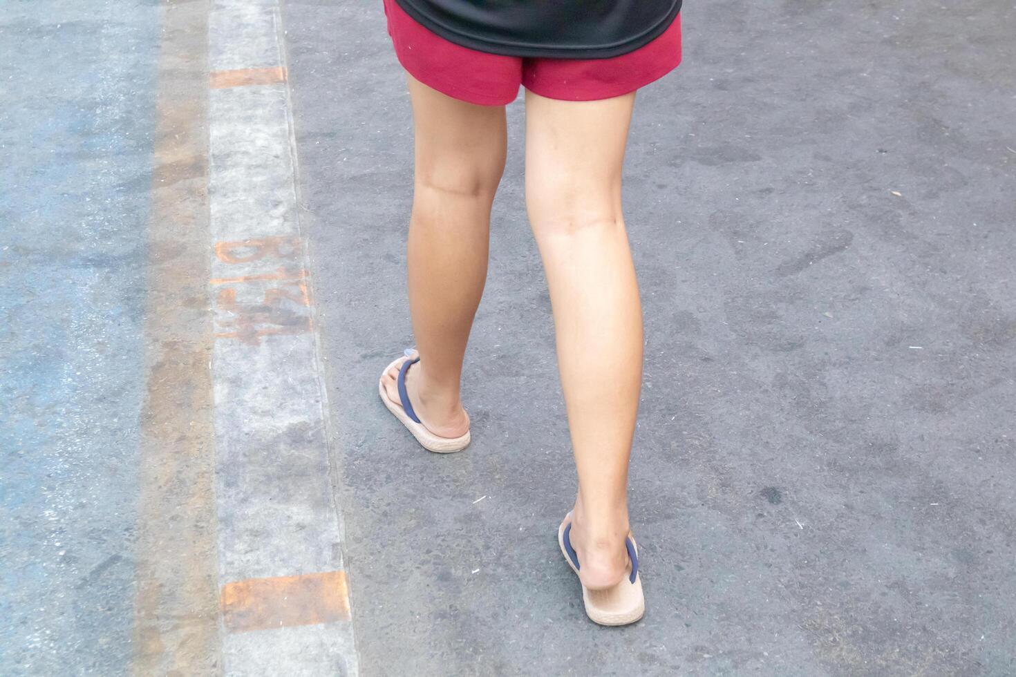 Backside view of person which walk on the concrete road. photo