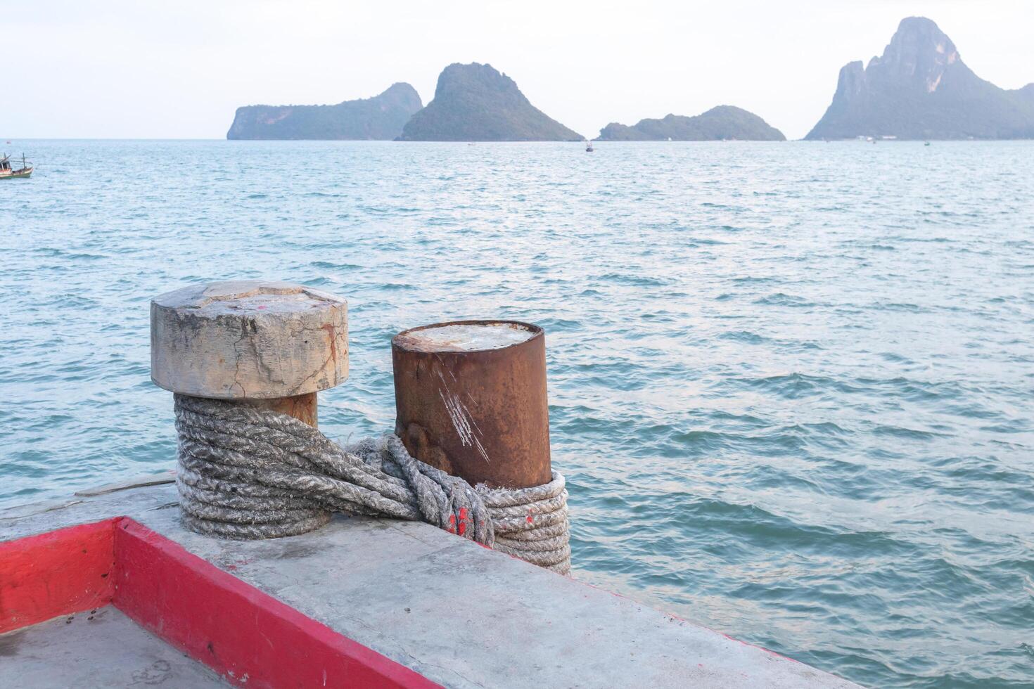 Steel pillar in the sea Is tied with a concrete post with a rope photo