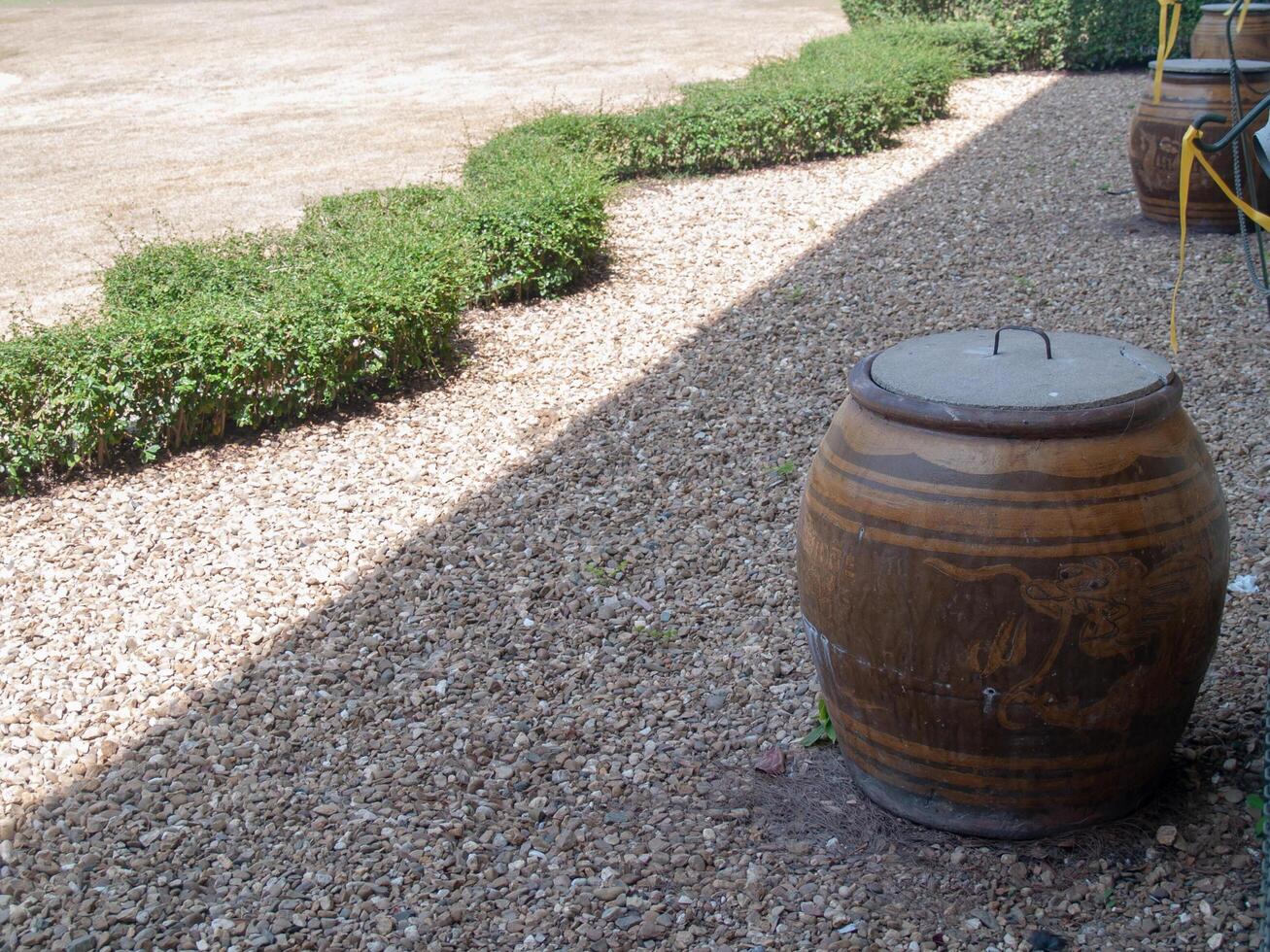 The jar of Thailand is covered with concrete. Located on a rocky area and trees And has a shadow of sunlight photo