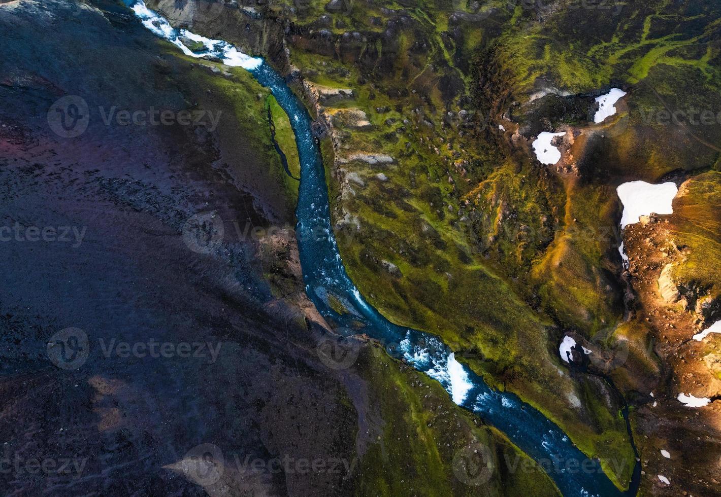 pintoresca montaña volcánica surrealista con río a través del campo de lava ubicada remotamente en las tierras altas de islandia foto