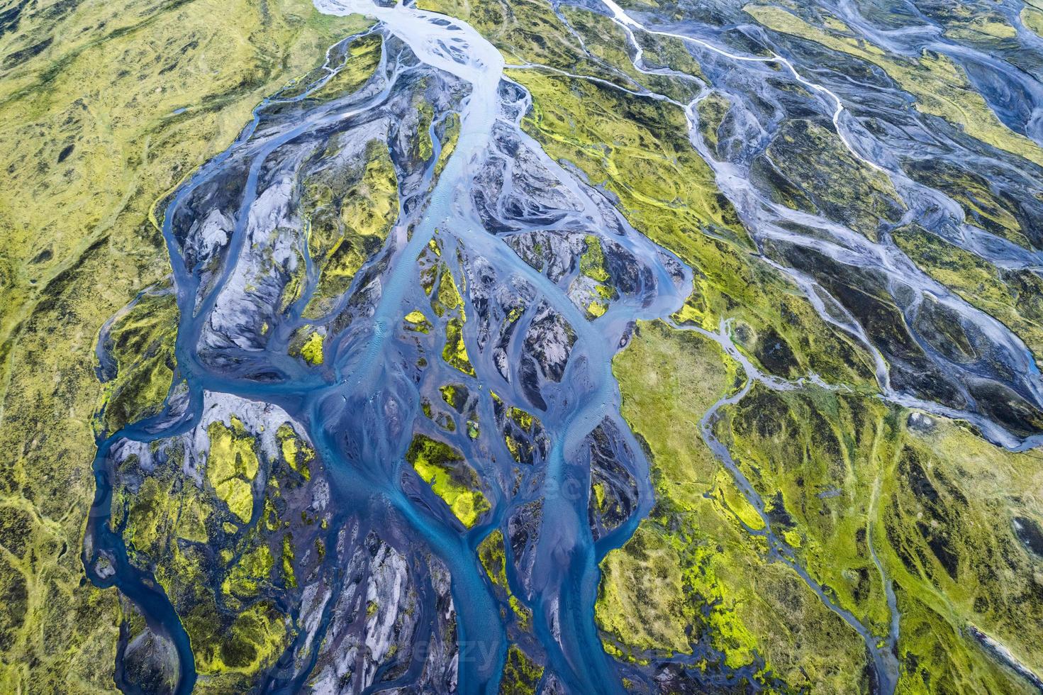 patrón abstracto de ríos glaciares azules que fluye a través del campo de musgo volcánico en las tierras altas islandesas en verano foto