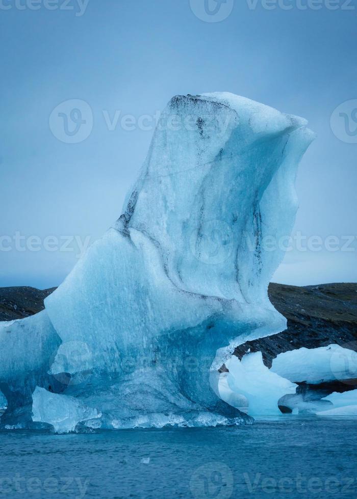 Blue iceberg floating on glacier lagoon from Breioamerkurjokull glacier in Jokulsarlon, Iceland photo