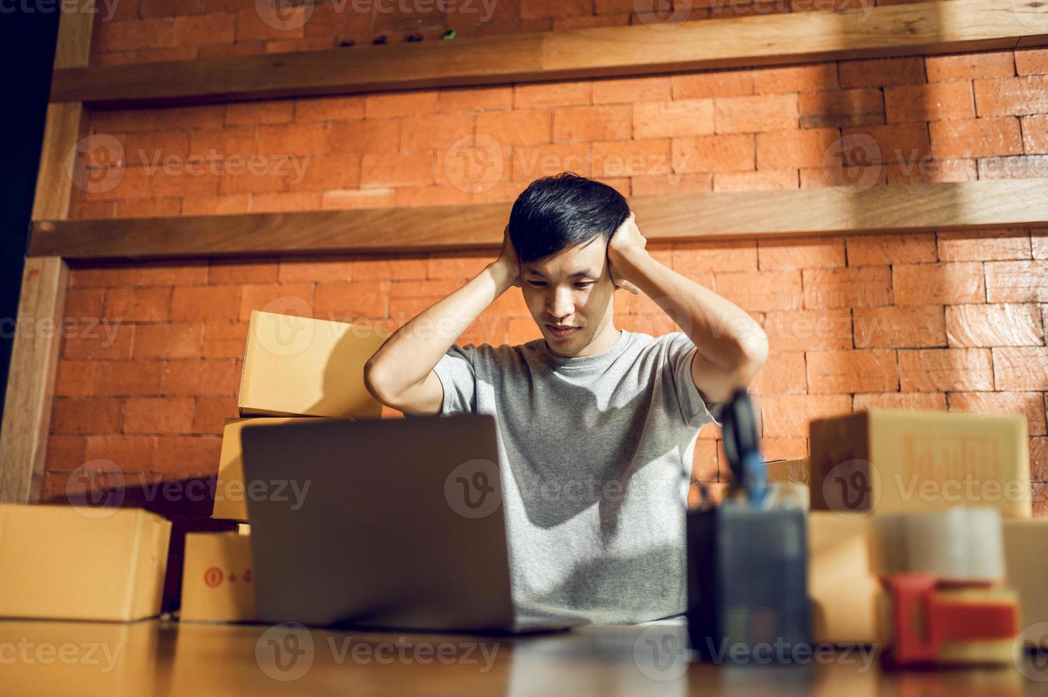 An Asian man uses a mobile phone to take orders and display items in a box that records live streaming video online at the store. small business owner Asian online market delivery concept photo