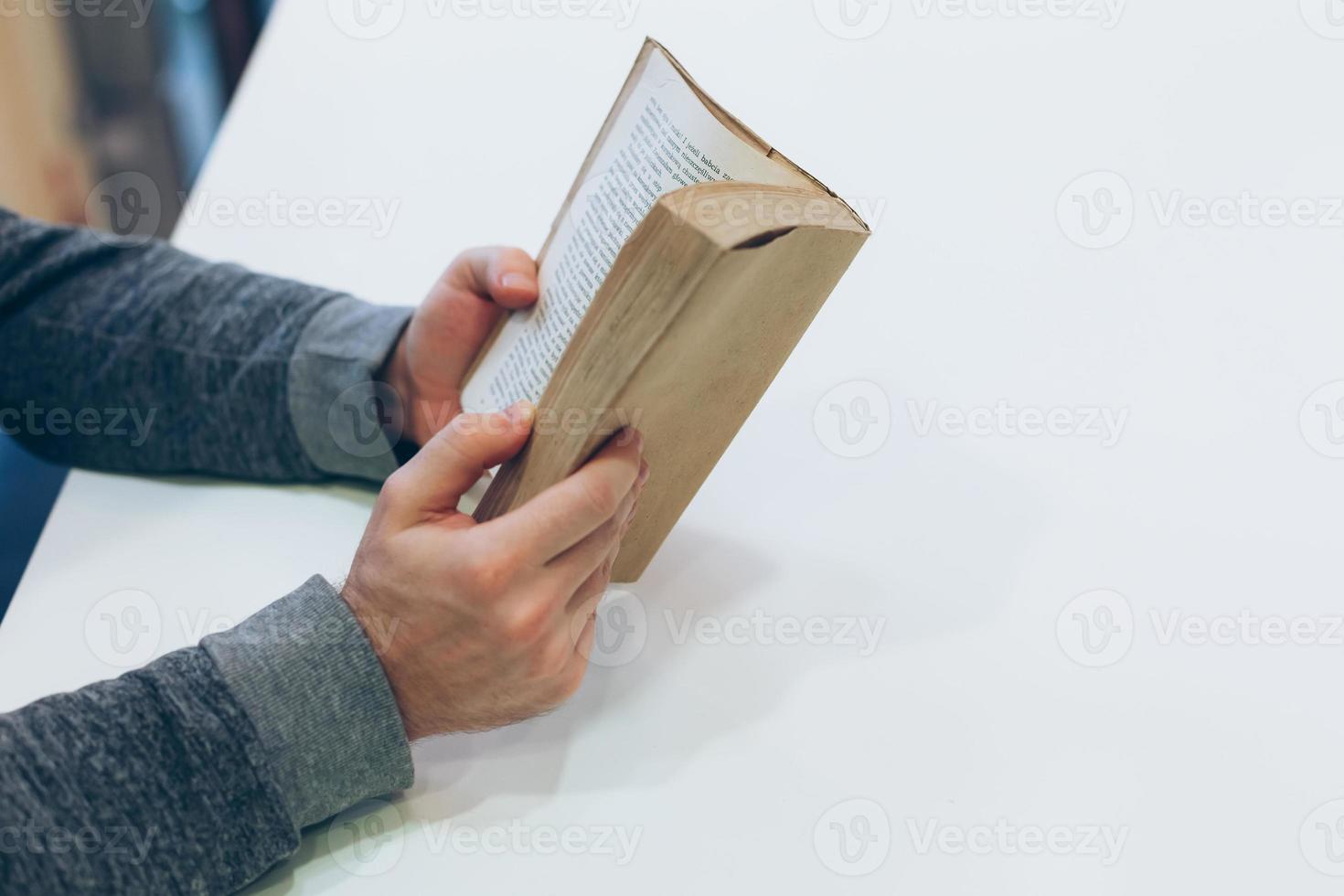 Young man reading open old paper book photo