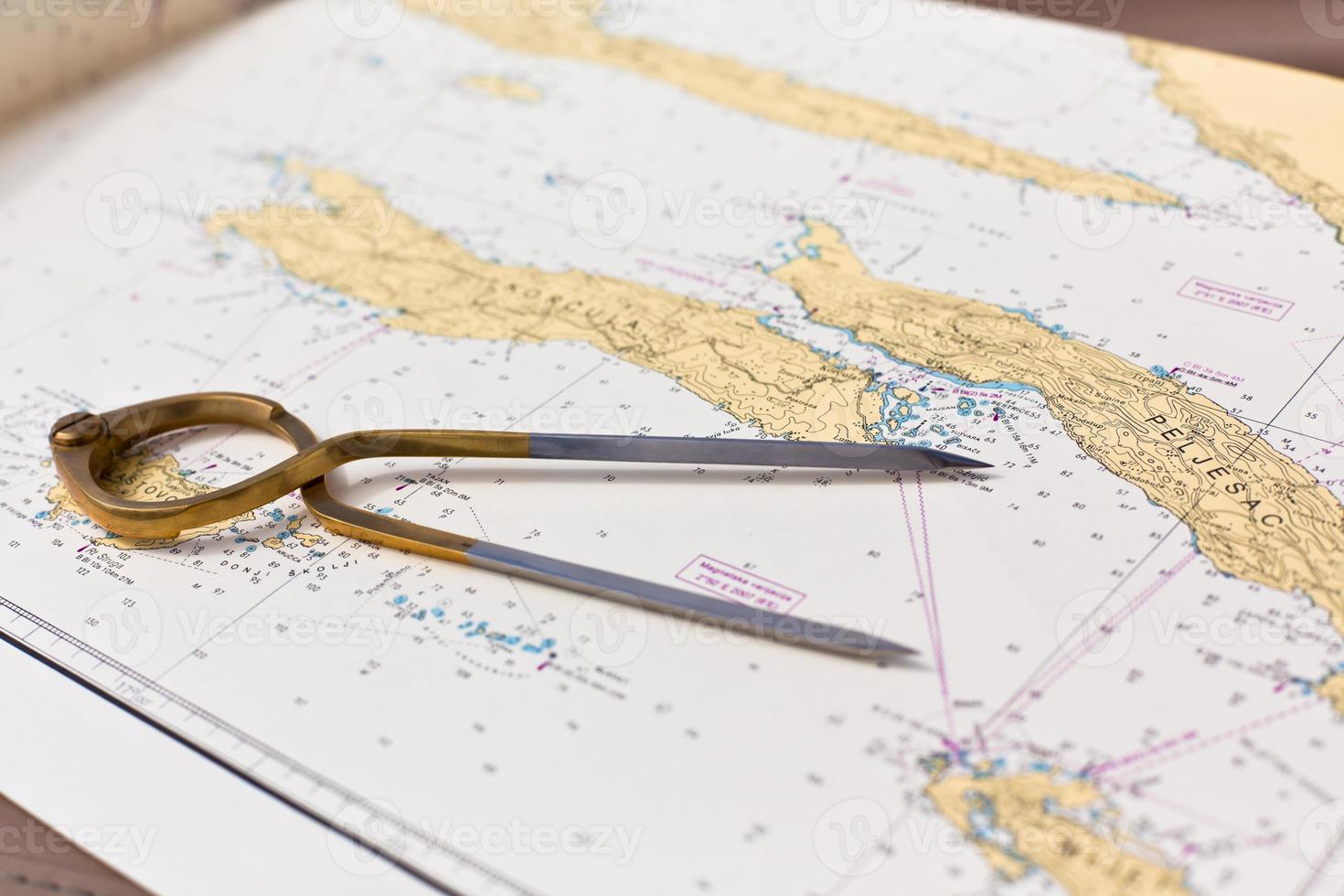 Pair of compasses for navigation on a sea map photo