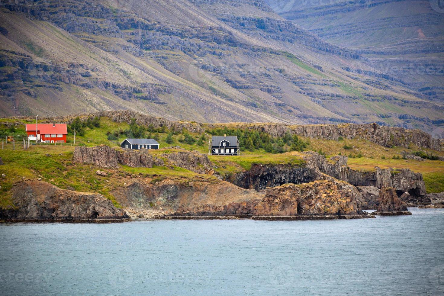 paisaje islandés con casas en montañas nubladas foto