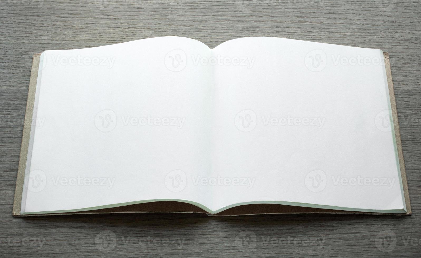 blank open book on dark wood background photo