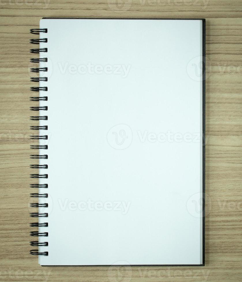 blank spiral notebook on wood background photo