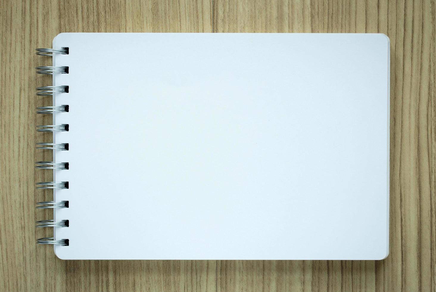 blank spiral notepad on wood background photo