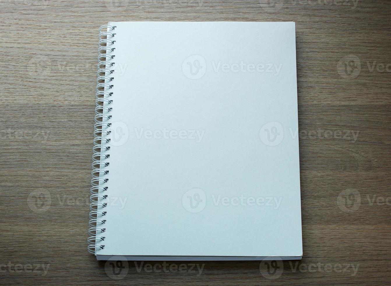 blank spiral notebook on dark wood background photo