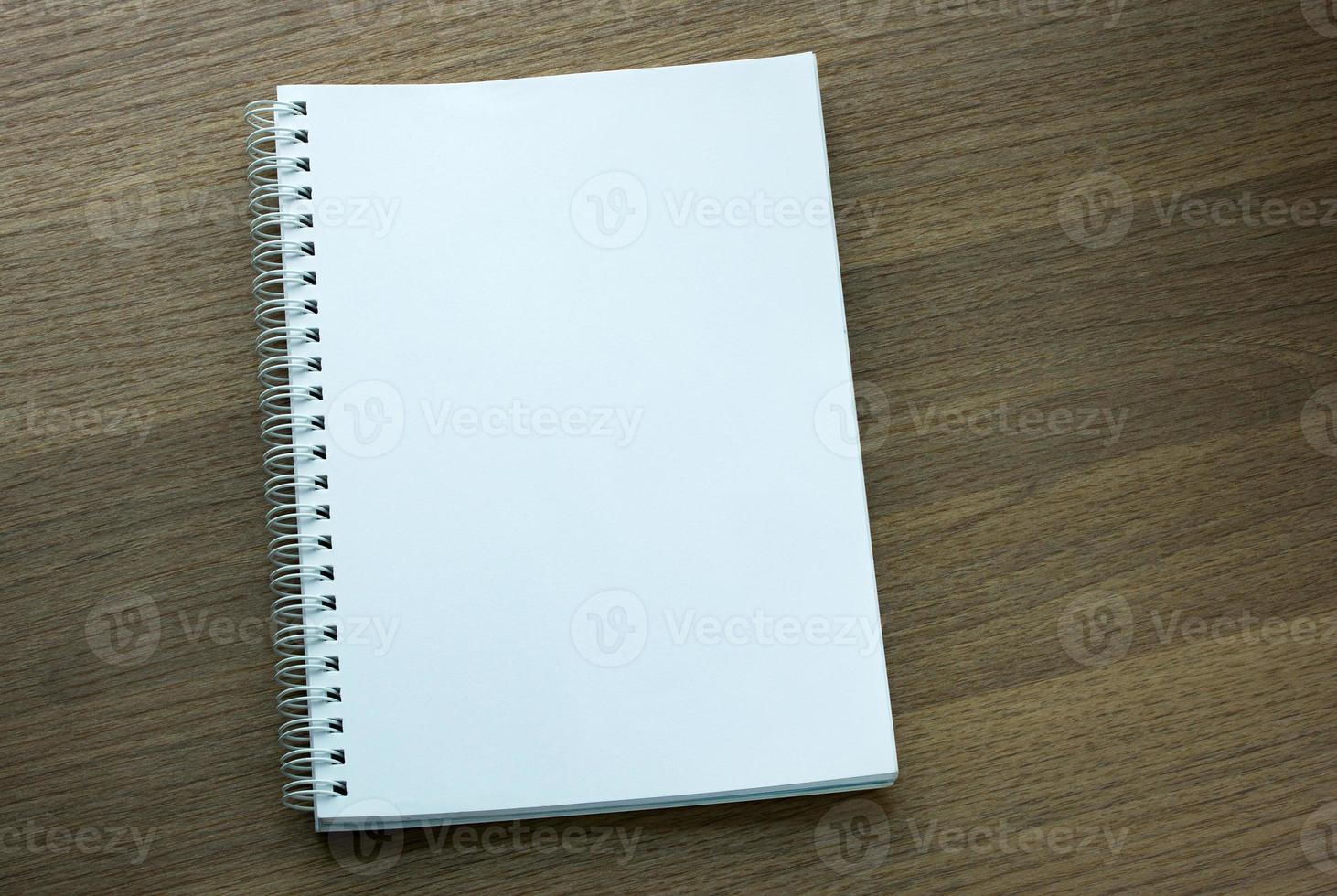 blank spiral notebook on dark wood background photo