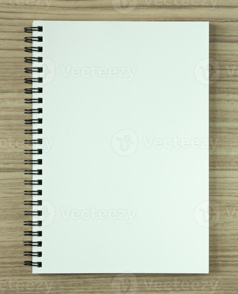 blank spiral notebook on wood background photo