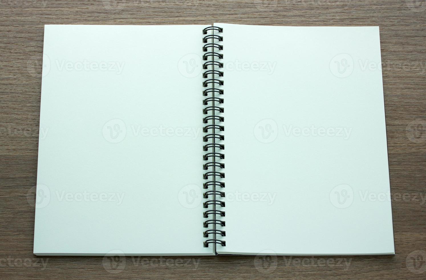 open spiral notebook on dark wood background photo