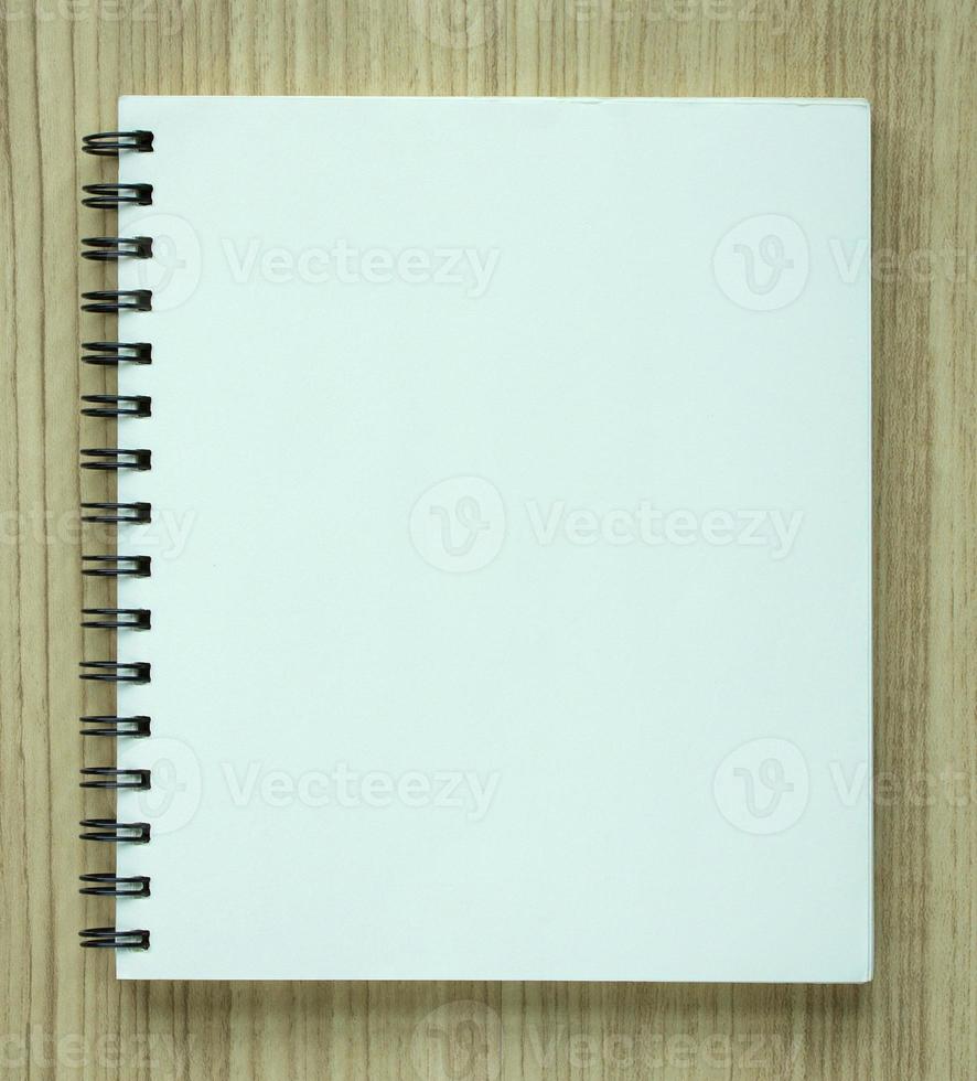 blank spiral notebook on wood background photo