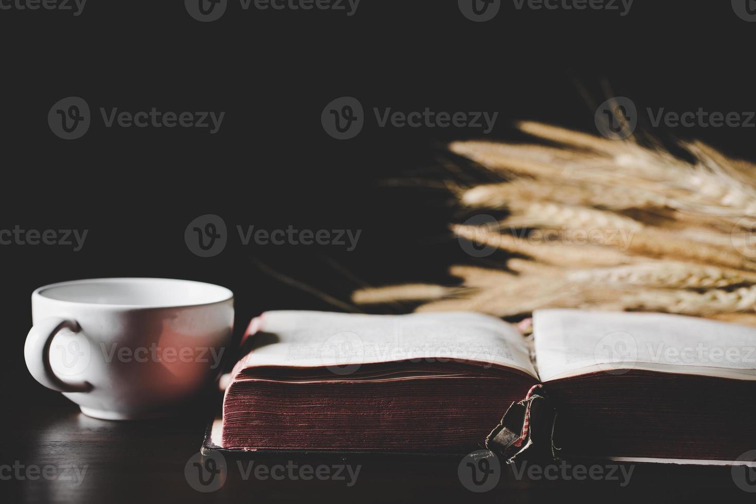 Holy bible book with paper for education on black wooden background. Christian catholic with protestant worship and pray in church. Concept of learning about faith god and religion, jesus spiritual. photo