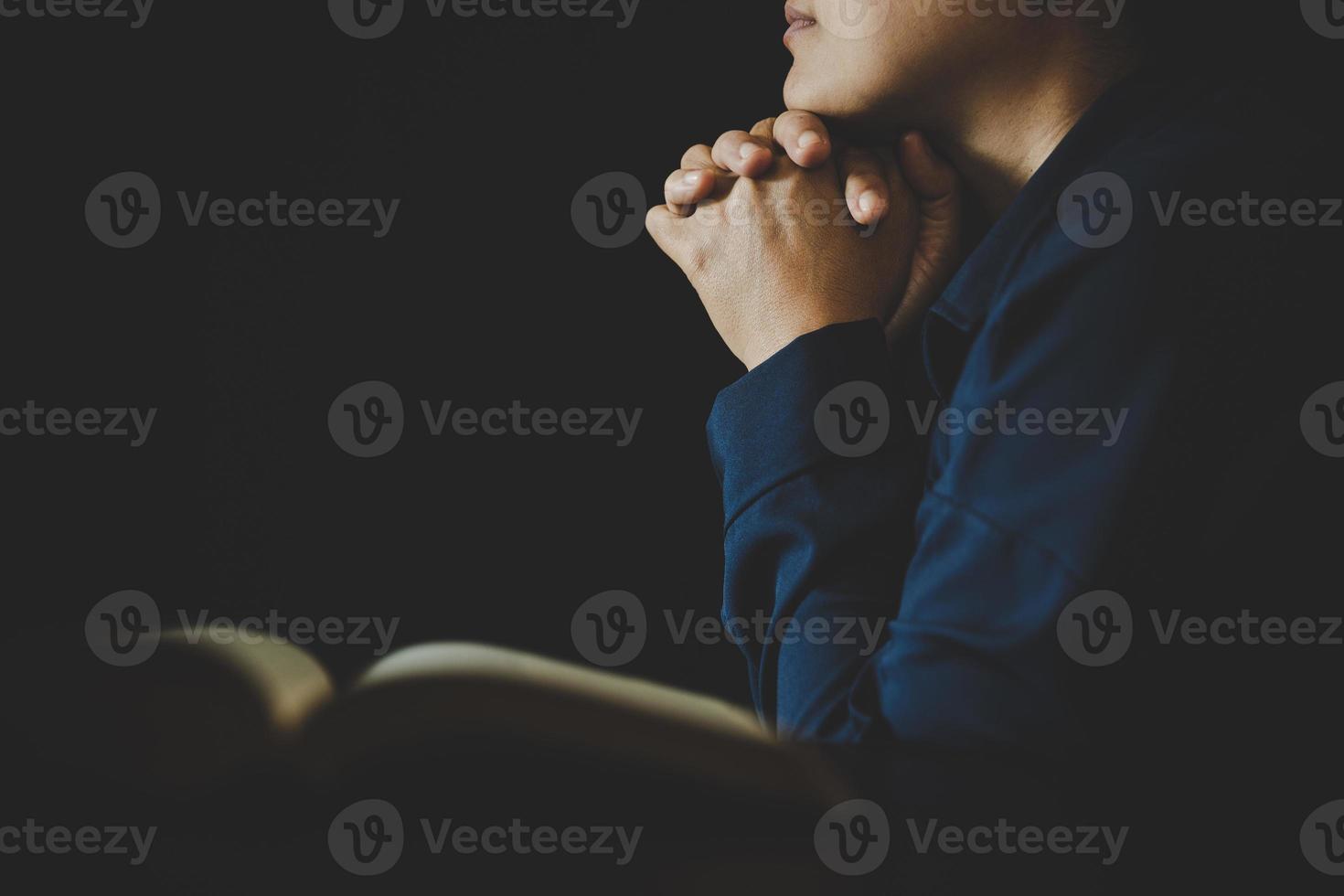 Hand folded in prayer to god on Holy Bible book in church concept for faith, spirituality and religion, woman person praying on holy bible in morning. christian catholic woman hand with Bible worship. photo