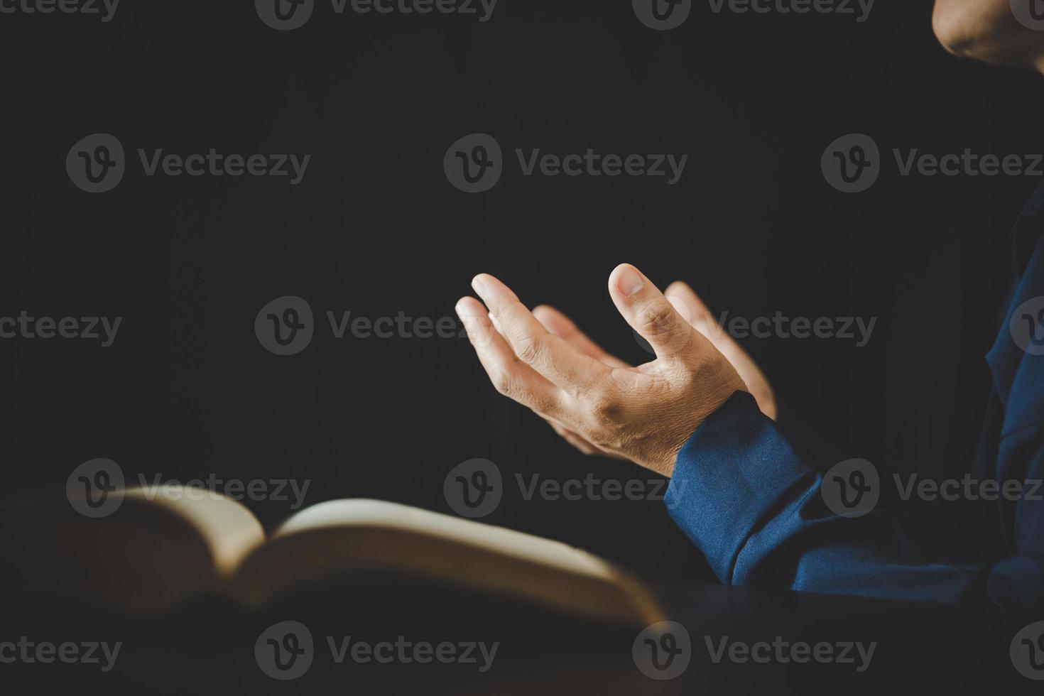 Hand folded in prayer to god on Holy Bible book in church concept for faith, spirituality and religion, woman person praying on holy bible in morning. christian catholic woman hand with Bible worship. photo