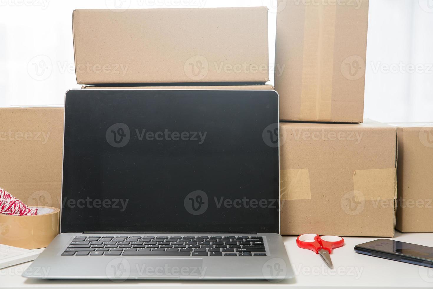 Equipments for SME online business, delivery business laptop, barcode, boxes, checking product on stocks or cardboard parcels. Small business working at home office. delivery service product at home. photo