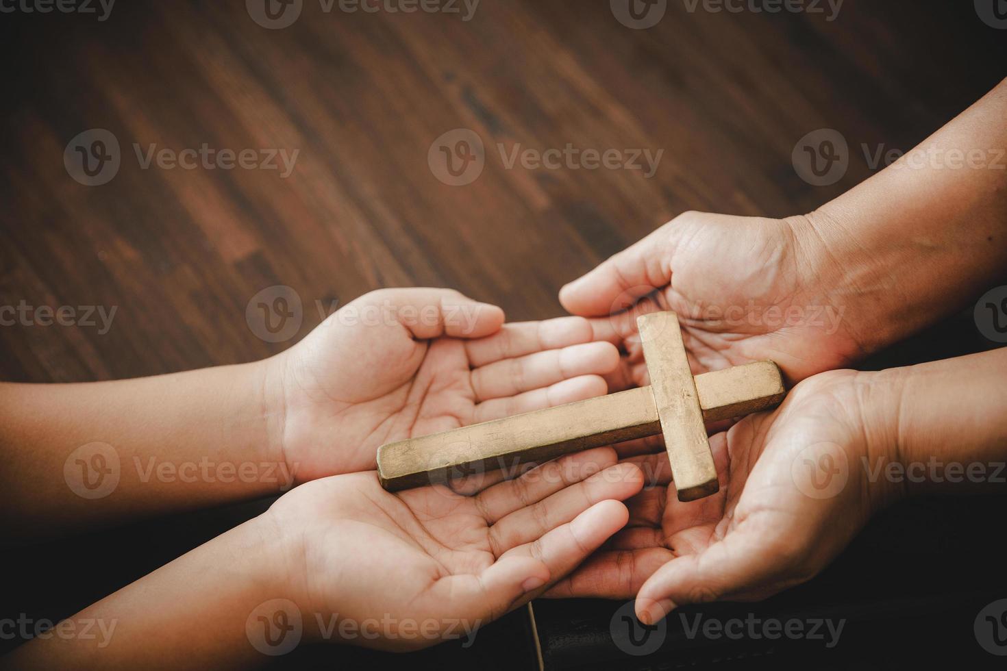 Cross in hand prayer to god on dark in church concept for faith spirituality and religion woman person praying on holy bible in morning. Christian catholic woman hand with worship in black background. photo
