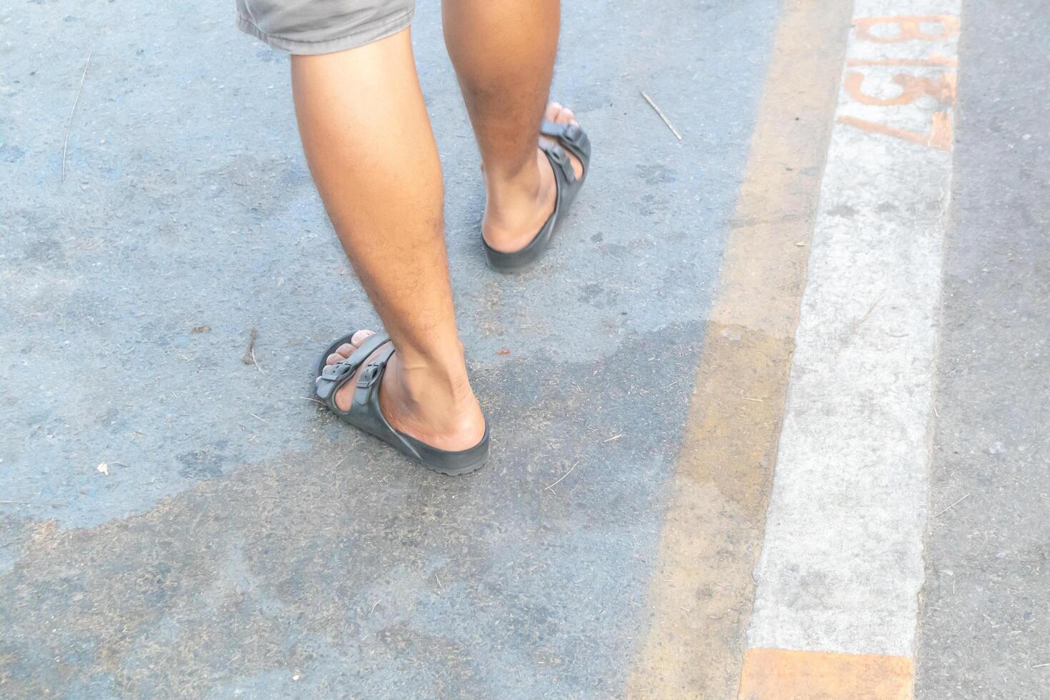 Backside view of person which walk on the concrete road. photo