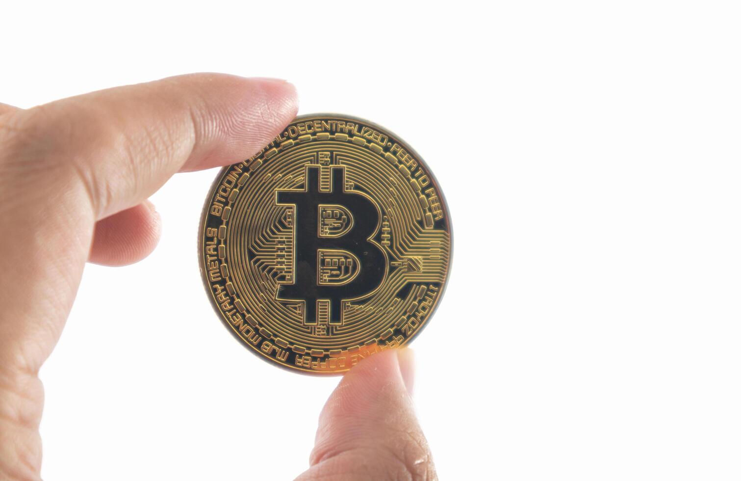Bitcoin sosteniendo en la mano aislado sobre fondo blanco con trazado de recorte. foto