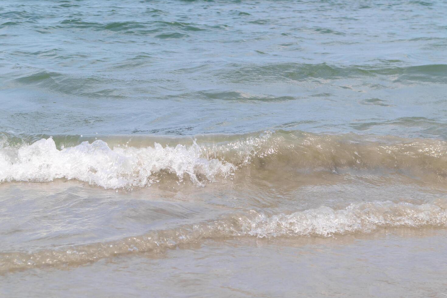 The ocean waves that blow into the beach at the time of clear sky photo