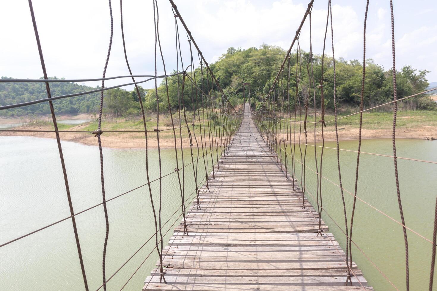 Suspension bridge on the river With mountains and sky in the background photo