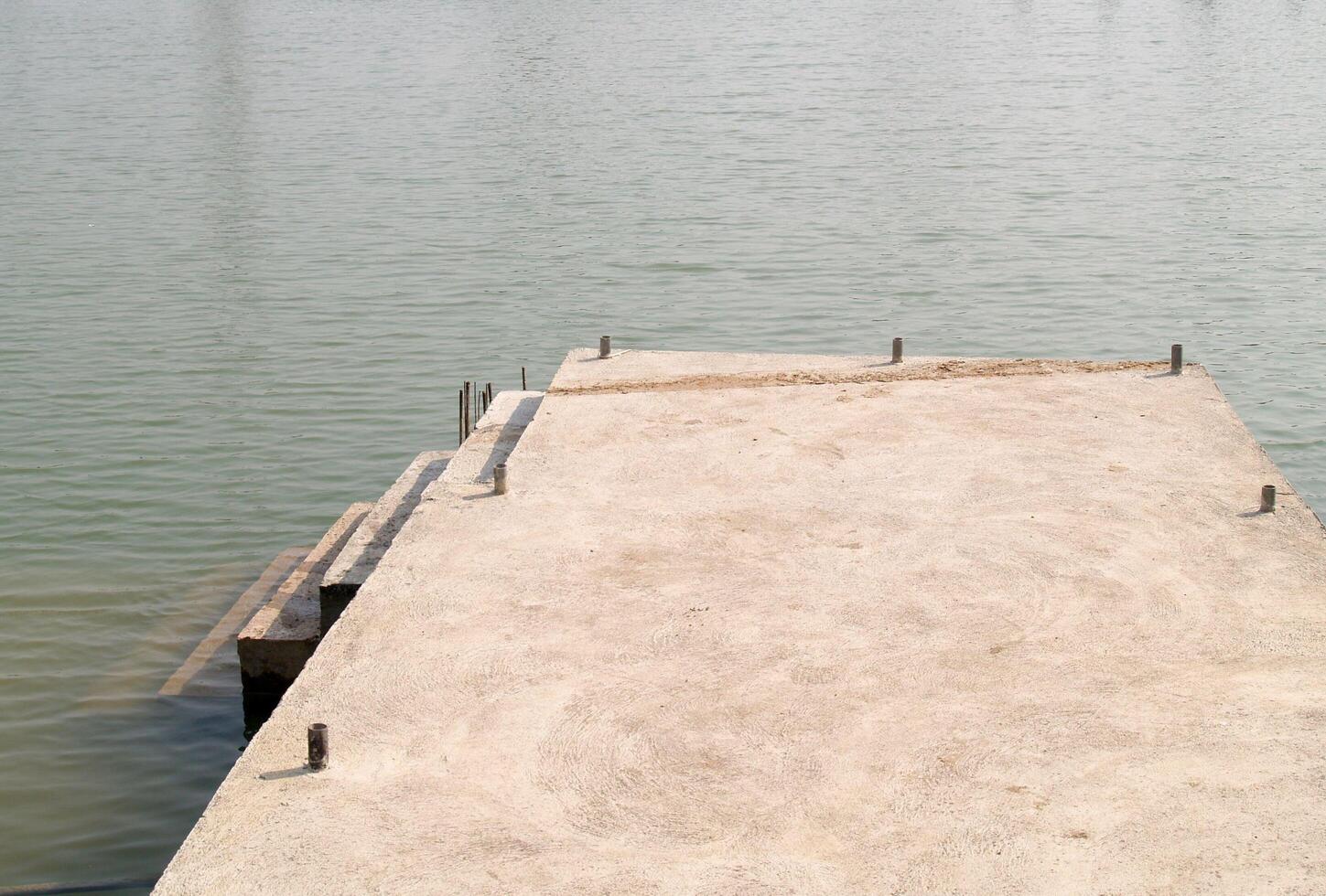 The waterfront is made of concrete and there is a path that can walk down into the pool photo