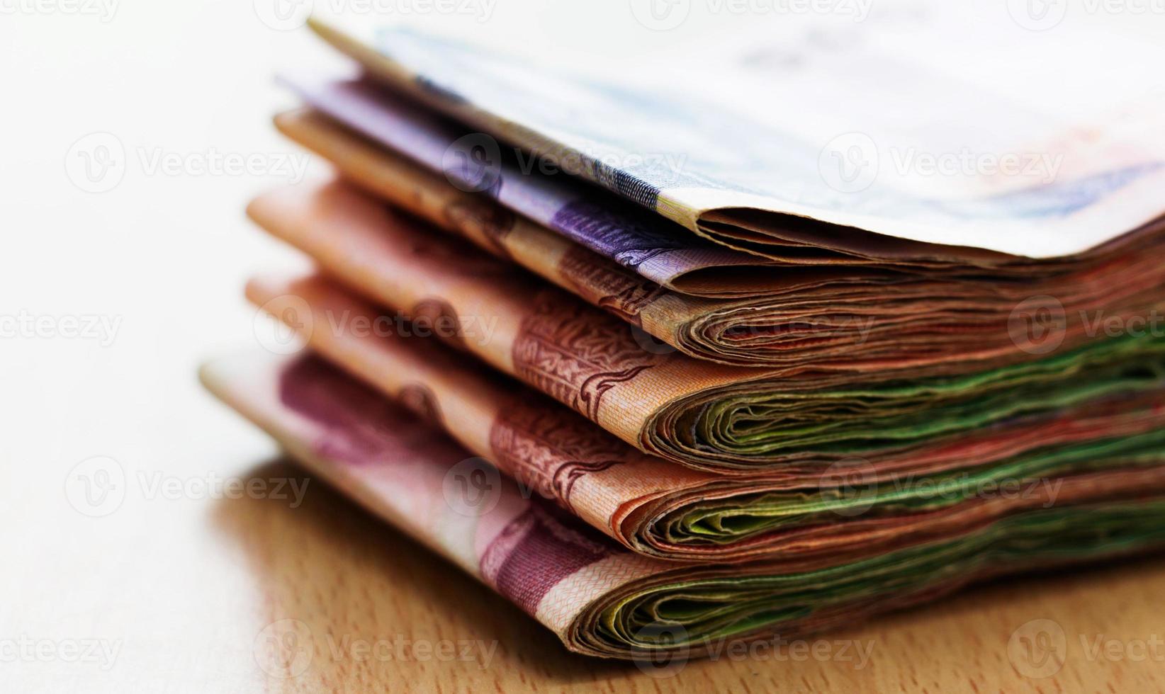 batches of thai banknote on table photo