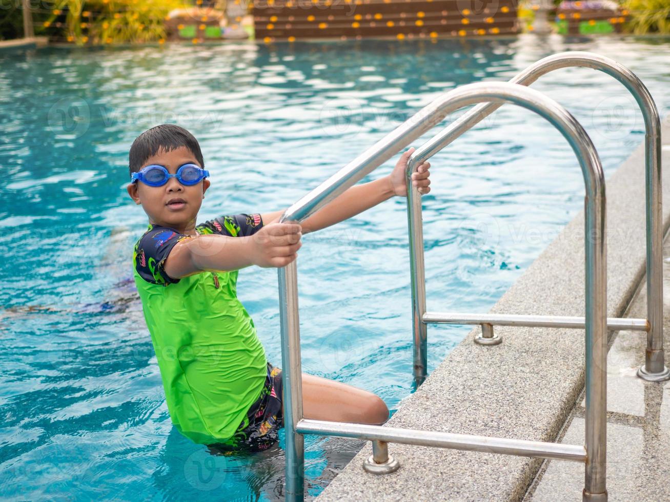 Niño con gorro de baño y gafas de natación en la piscina el niño