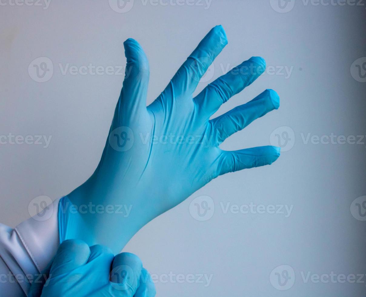 mano en un guante azul sobre un fondo blanco foto