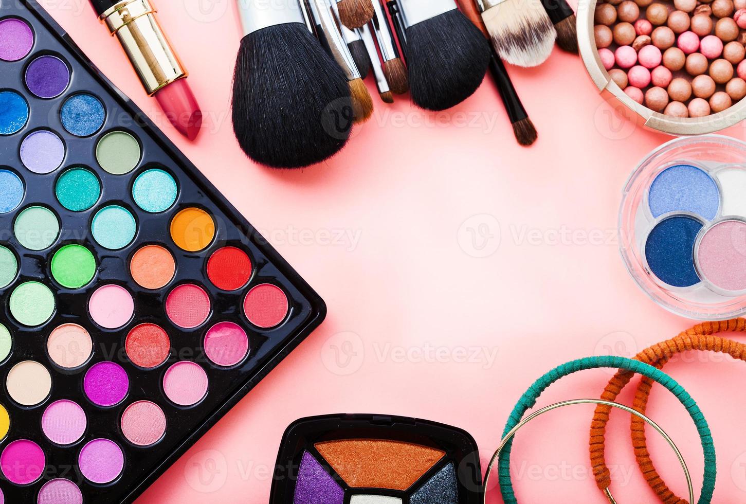 Frame of cosmetic accessories on pink background with copy space. Top view photo