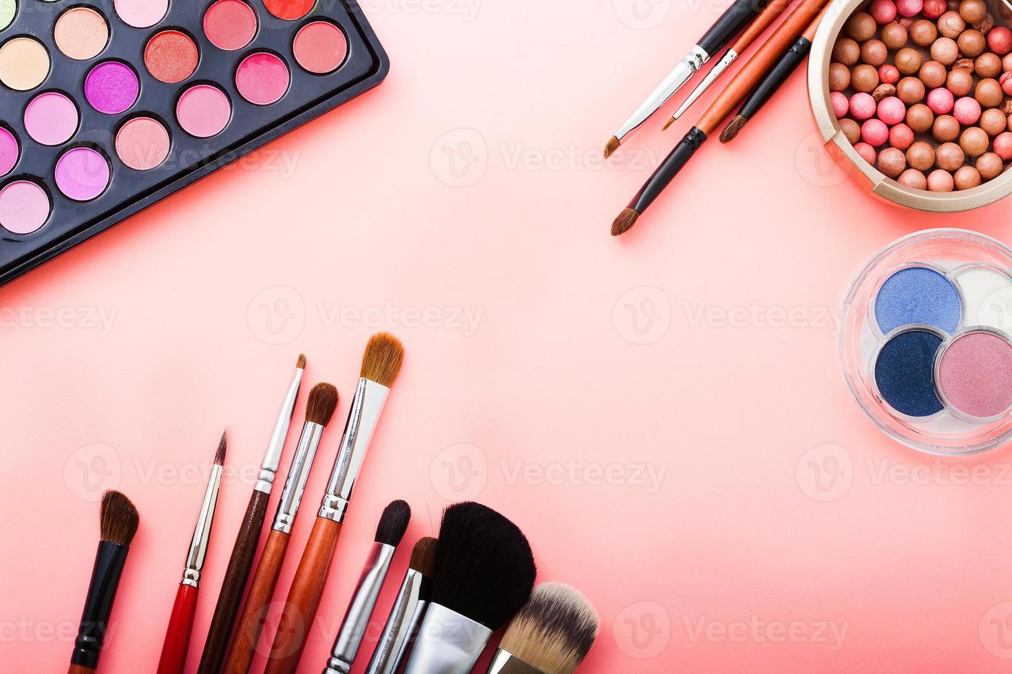 Frame of cosmetic accessories on pink background with copy space. Top view photo