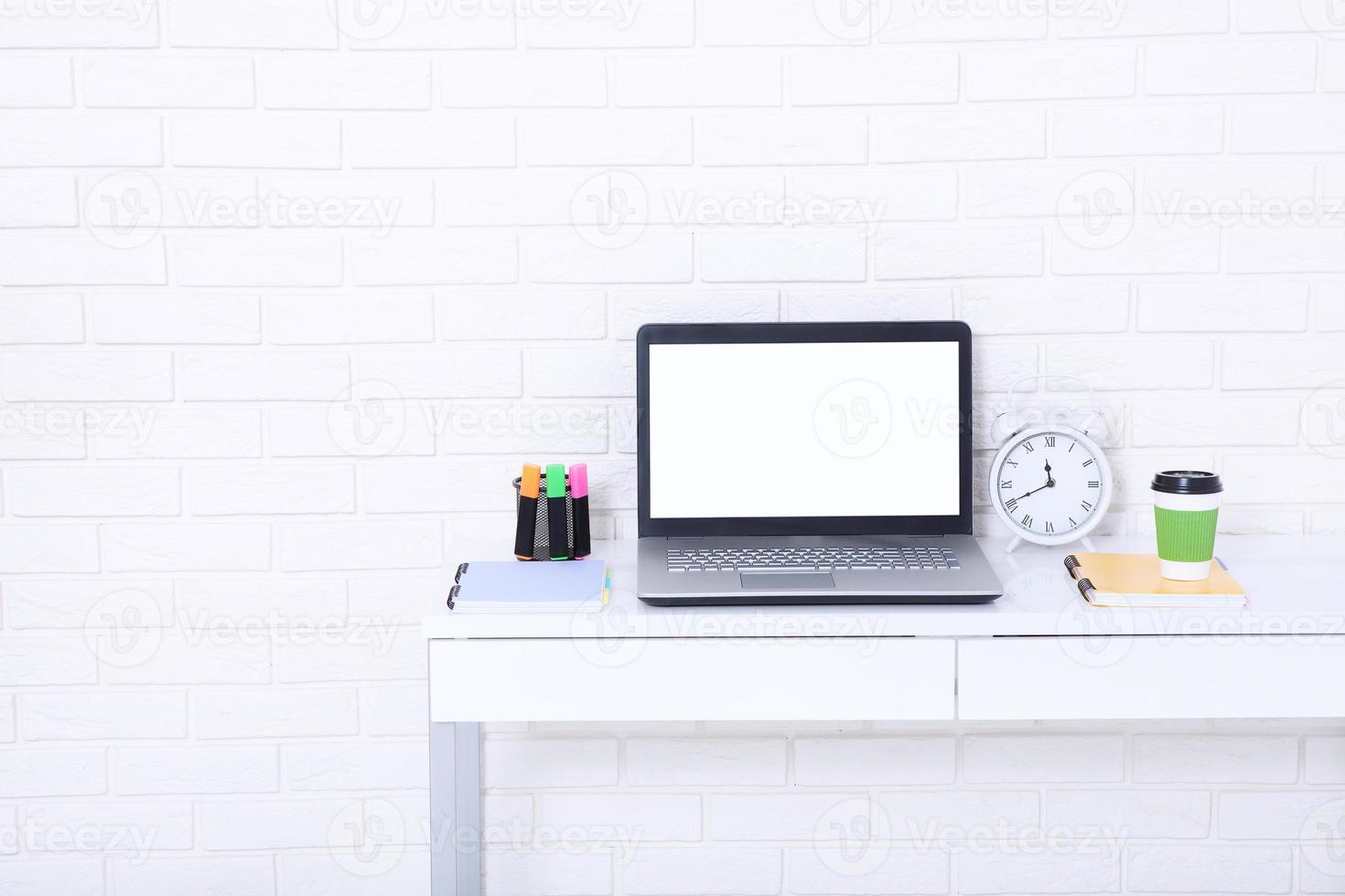 Education accessories on the table near brick wall. Empty computer and mobile screen with place for text. photo