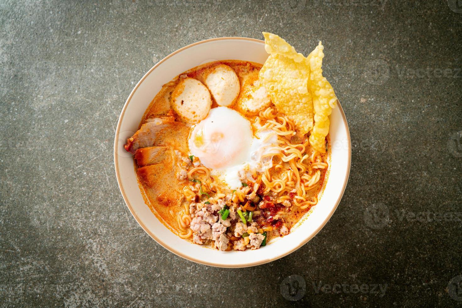 instant noodles with pork and meatballs in spicy soup photo