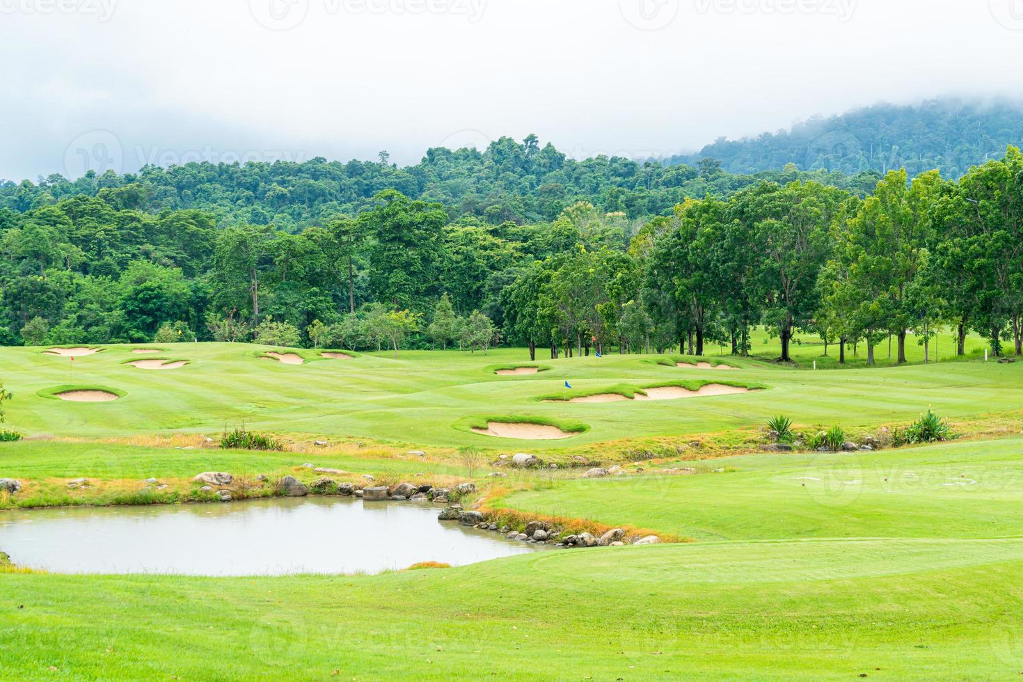 green con bunkers de arena en campo de golf foto