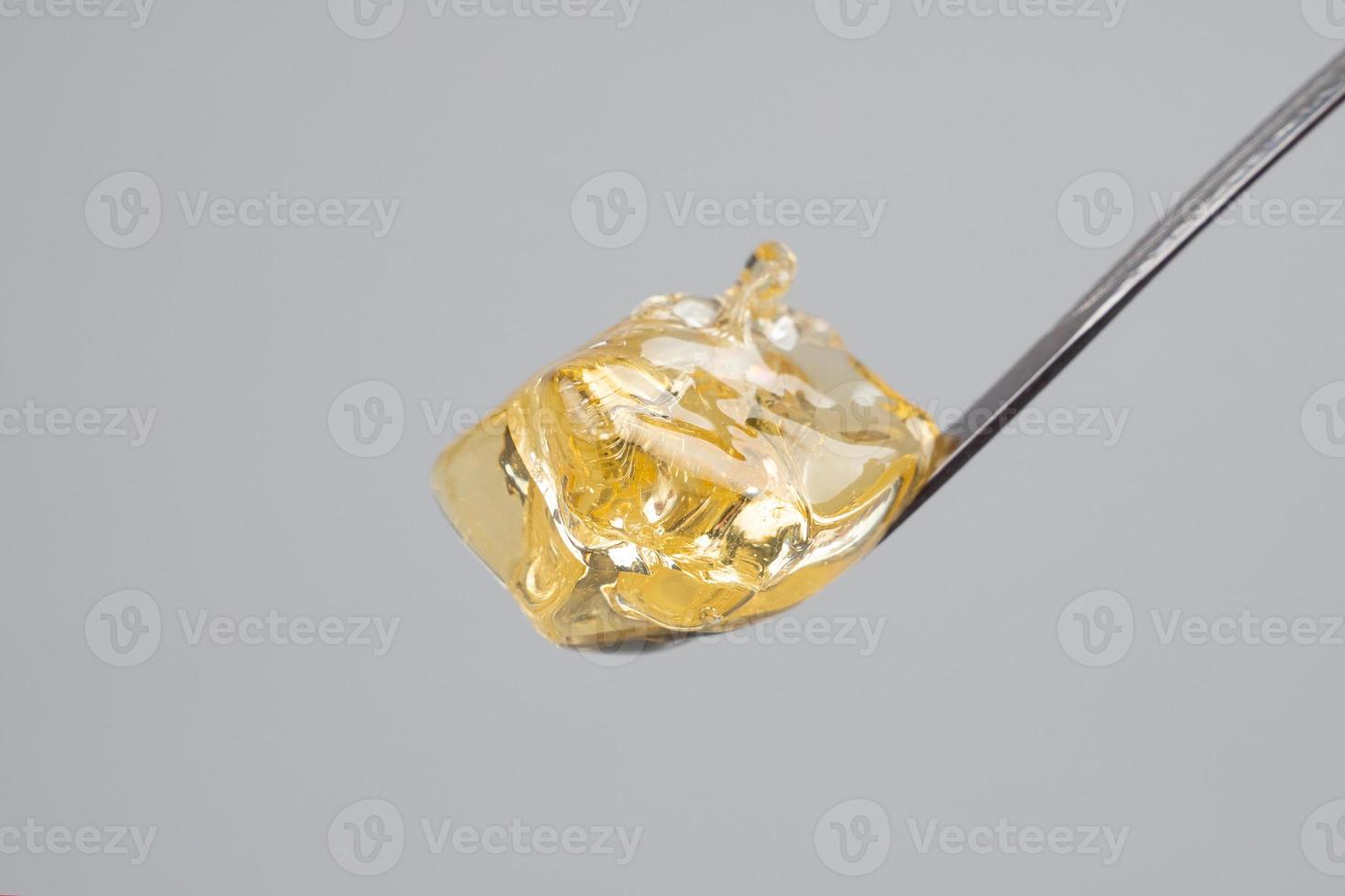 yellow clean cannabis wax, concentrate marijuana and dabbing tool close-up photo