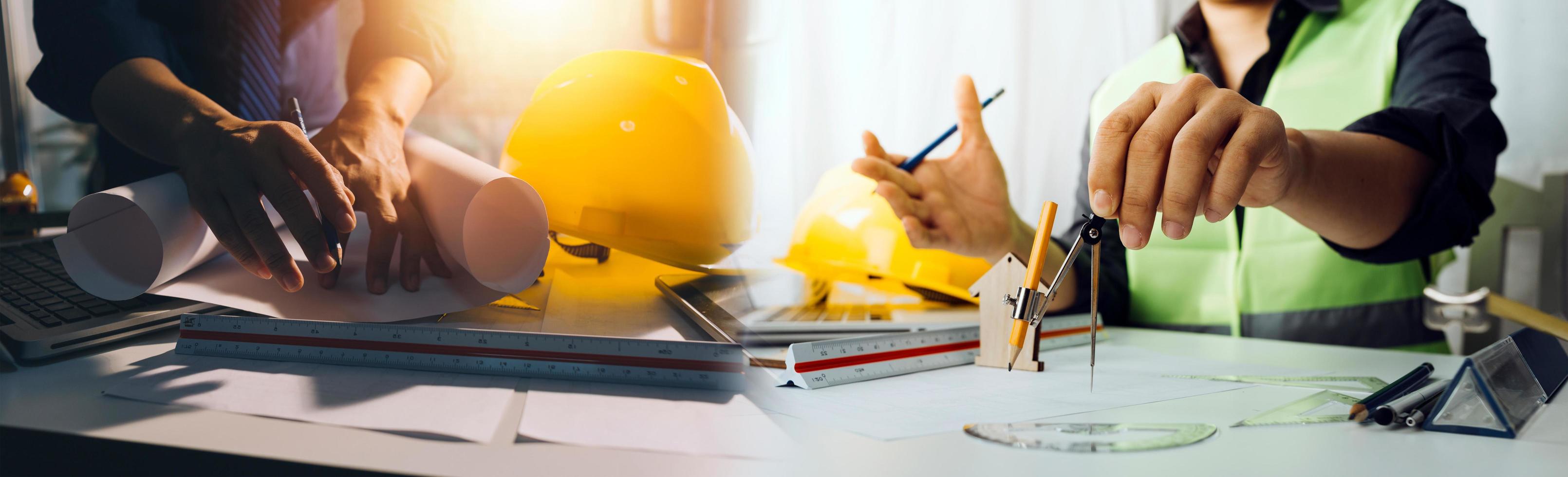 business hand working and laptop with on on architectural project at construction site at office desk in office photo
