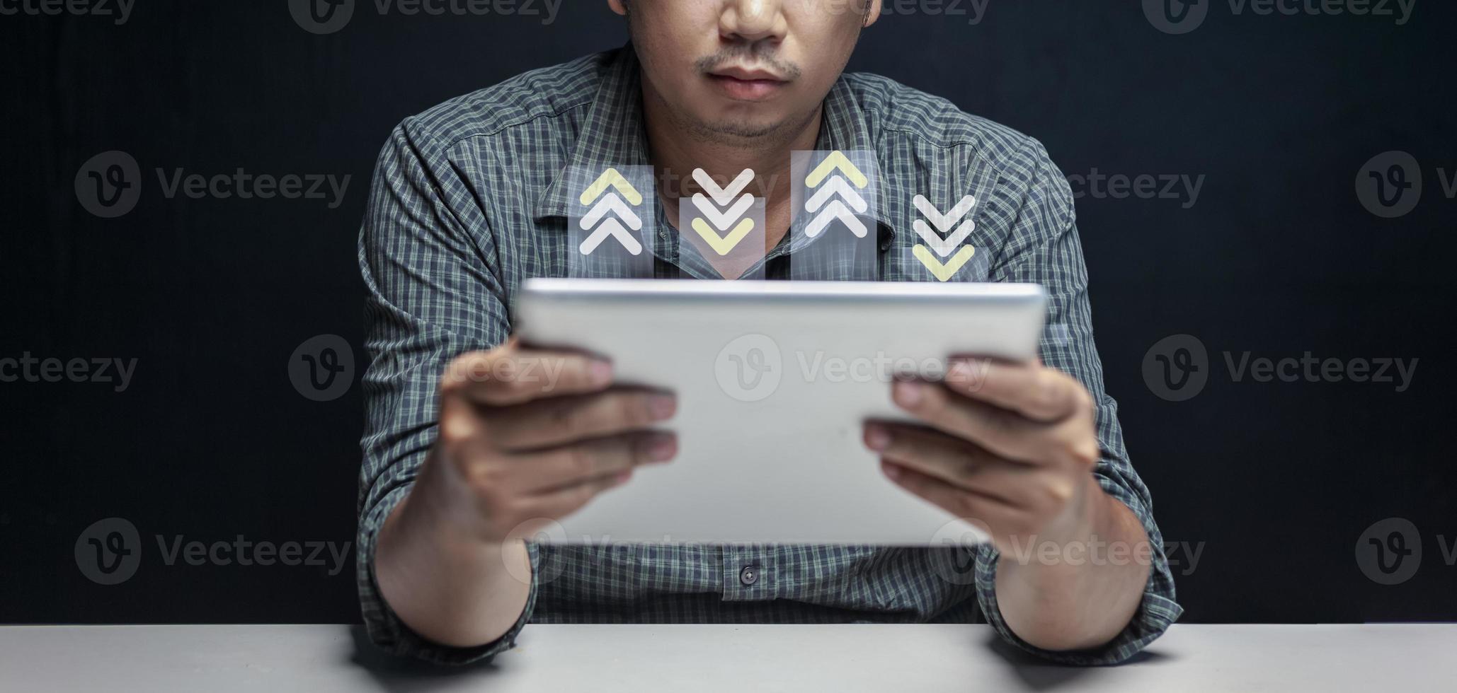 Small businessman looking at sales chart on tablet in his room at home. photo