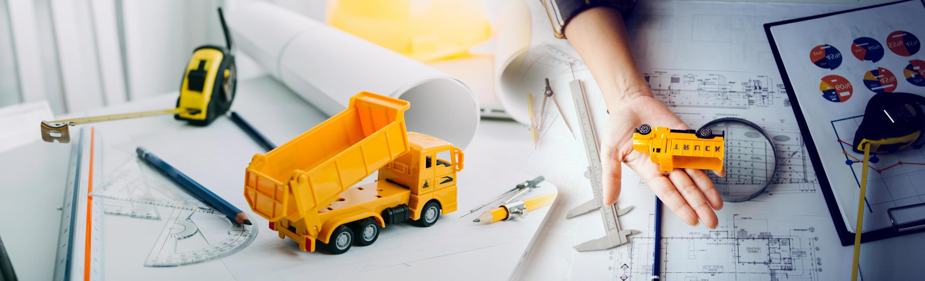 business hand working and laptop with on on architectural project at construction site at office desk in office photo